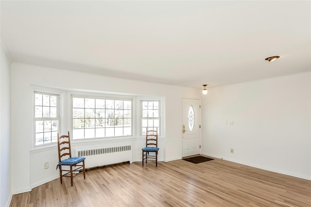 entrance foyer featuring radiator, baseboards, and light wood finished floors