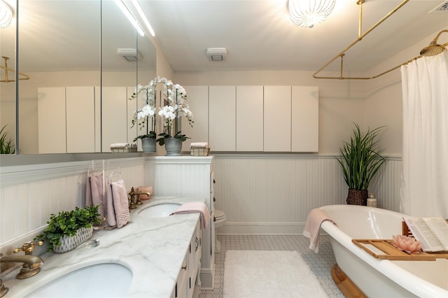71 Old Mountain Rd S, Nyack, NY 10960 - full bath with a soaking tub, double vanity, a shower with shower curtain, wainscoting, and toilet