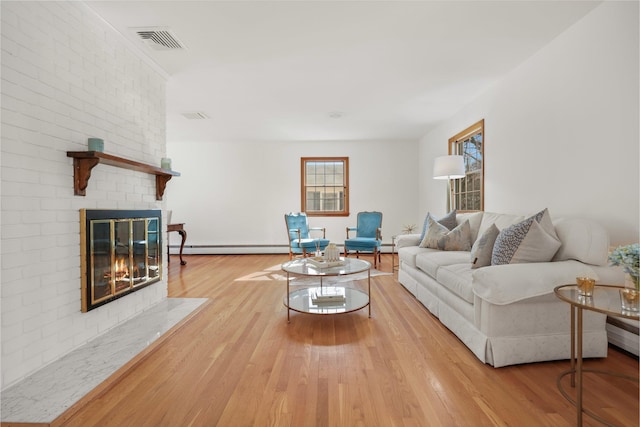 living room with a fireplace, visible vents, baseboard heating, and wood finished floors