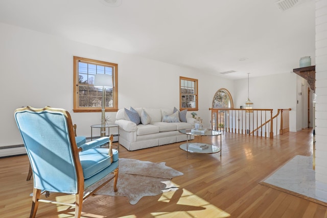 living area featuring visible vents and wood finished floors