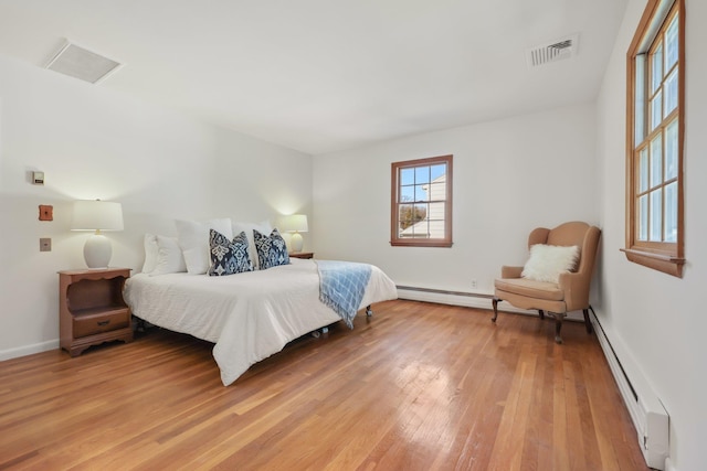 bedroom featuring a baseboard radiator, visible vents, baseboard heating, light wood-style floors, and baseboards