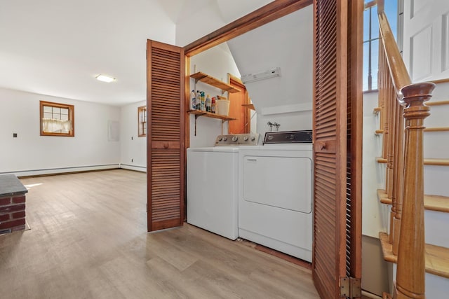 washroom featuring a baseboard heating unit, laundry area, light wood-style flooring, and separate washer and dryer