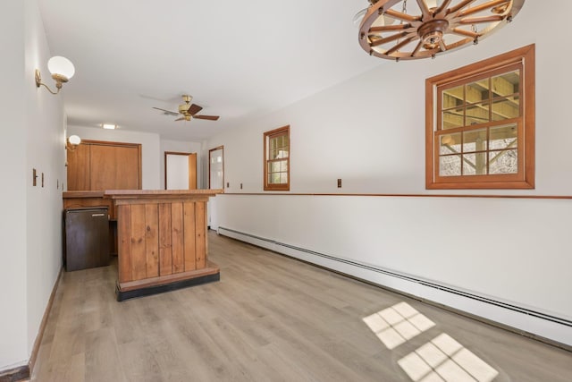 kitchen featuring pendant lighting, brown cabinets, light wood finished floors, a baseboard heating unit, and a ceiling fan