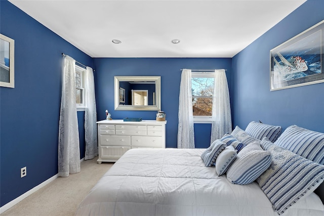 bedroom featuring light colored carpet and baseboards