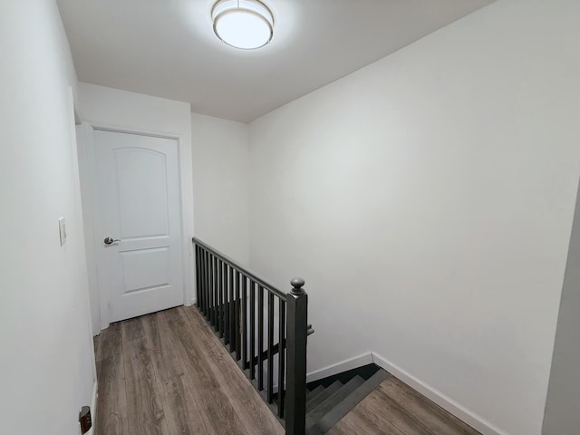 staircase featuring baseboards and wood finished floors