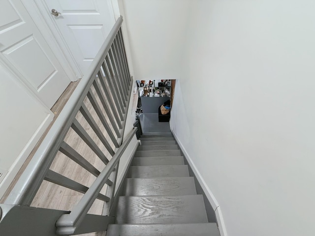 staircase featuring baseboards and wood finished floors