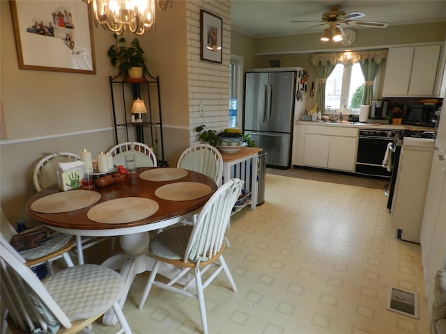 dining space with visible vents, light floors, and ceiling fan with notable chandelier