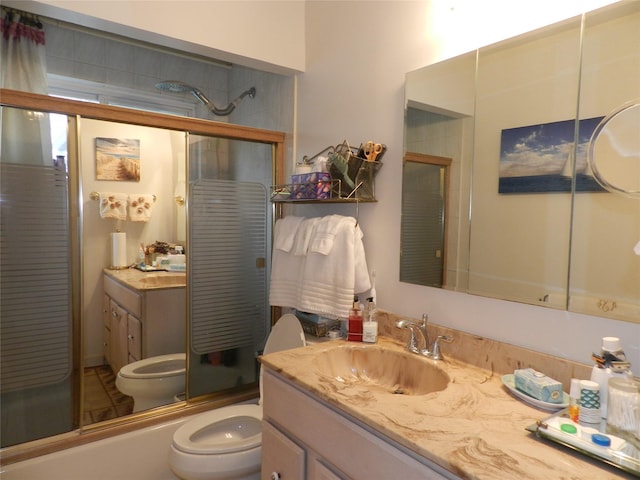 full bath with combined bath / shower with glass door, vanity, and toilet