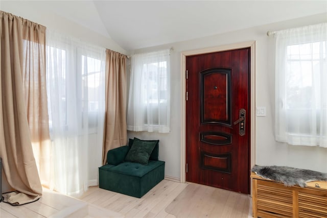 sitting room with vaulted ceiling, light wood finished floors, and a wealth of natural light