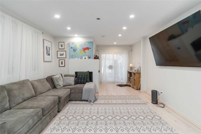 living room featuring a fireplace, wood finished floors, and recessed lighting