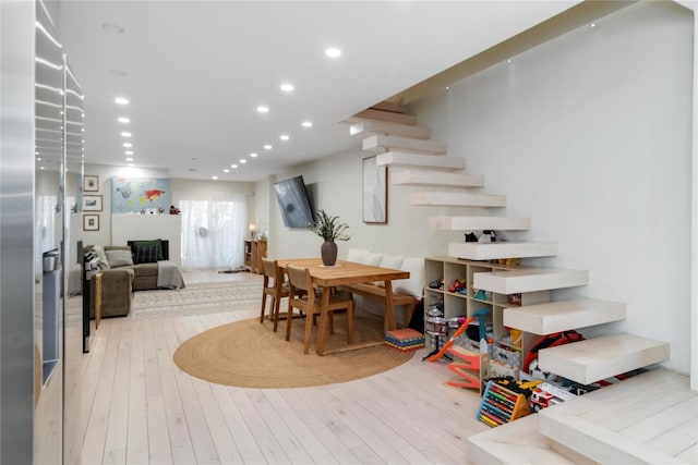 dining room with stairway, light wood-style flooring, and recessed lighting