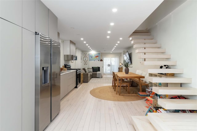 interior space with light wood-type flooring, recessed lighting, and stairway