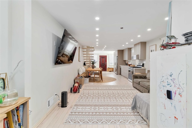 living room with recessed lighting, visible vents, and light wood-style flooring