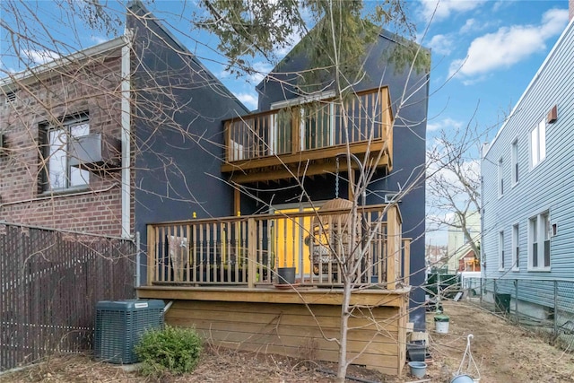 back of house with a balcony, fence, and central AC unit