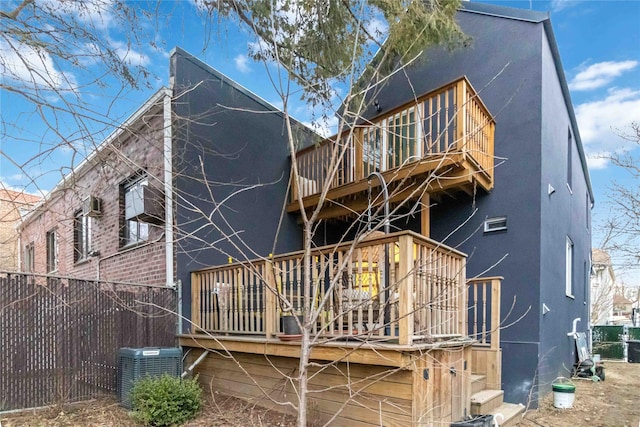 back of house featuring fence, cooling unit, and stucco siding