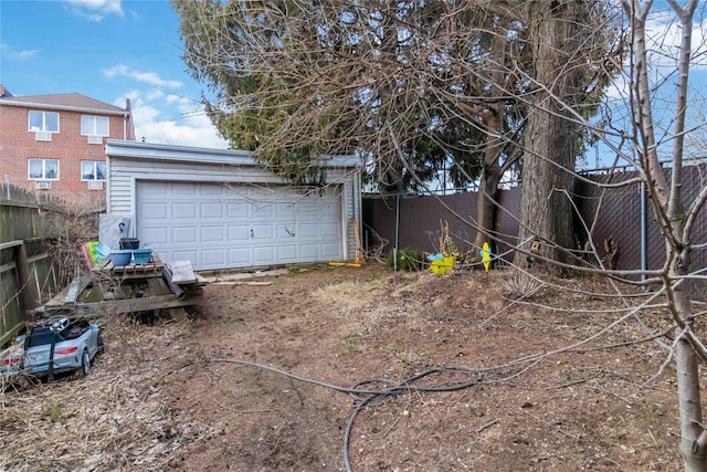 detached garage featuring fence