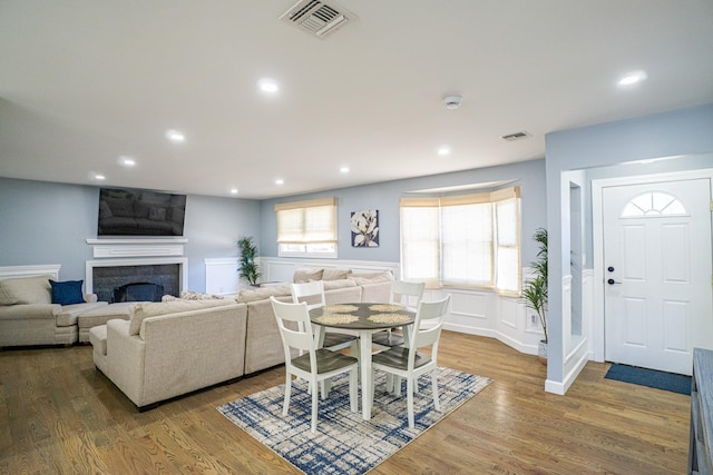 dining room with recessed lighting, visible vents, a fireplace, and wood finished floors