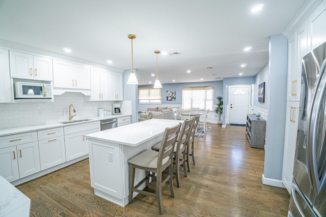 kitchen with visible vents, dark wood-style floors, appliances with stainless steel finishes, open floor plan, and a sink