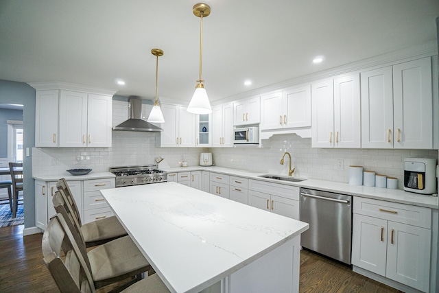 kitchen featuring range, white microwave, stainless steel dishwasher, wall chimney range hood, and a sink