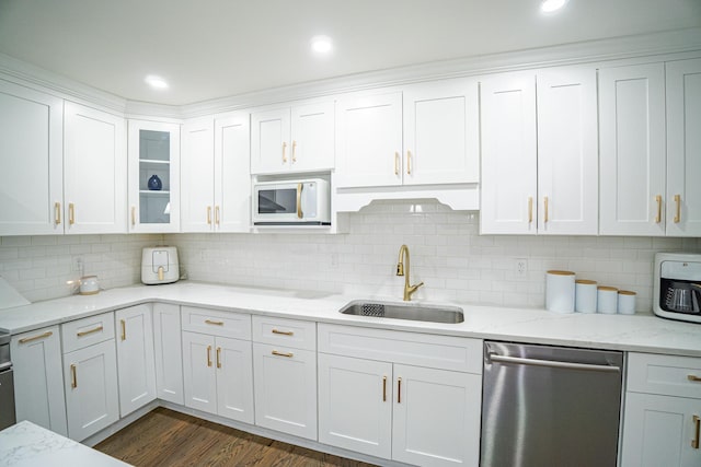 kitchen featuring stainless steel dishwasher, white microwave, glass insert cabinets, white cabinets, and a sink