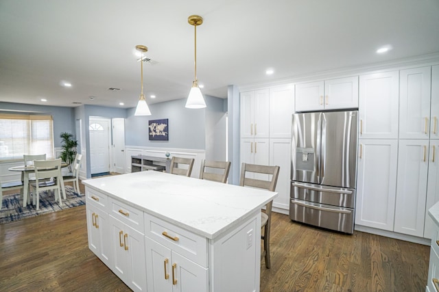 kitchen featuring stainless steel fridge, white cabinets, dark wood-type flooring, a center island, and hanging light fixtures