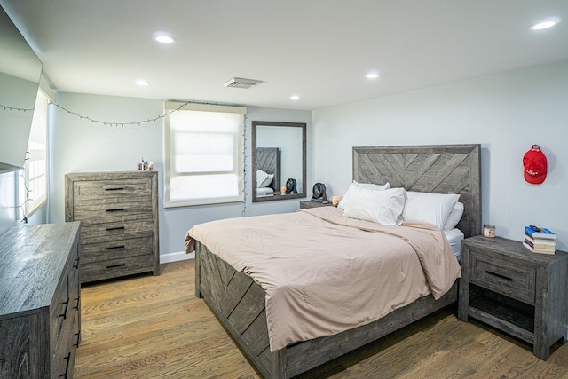 bedroom featuring recessed lighting, visible vents, baseboards, and wood finished floors