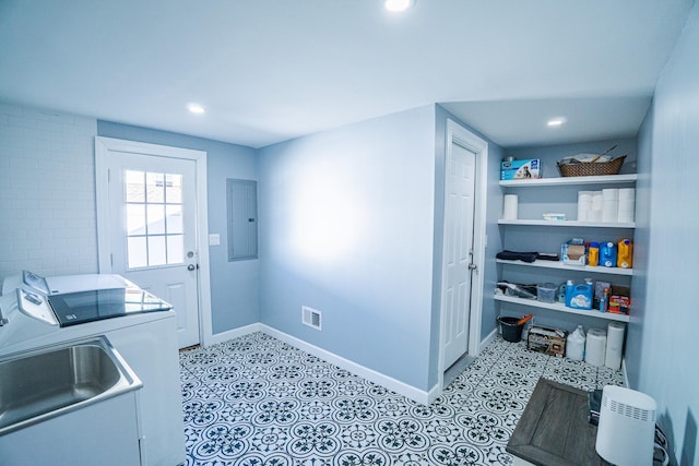 washroom with laundry area, baseboards, visible vents, washer and dryer, and a sink