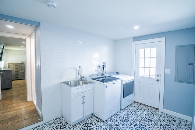 clothes washing area featuring recessed lighting, cabinet space, a sink, separate washer and dryer, and electric panel