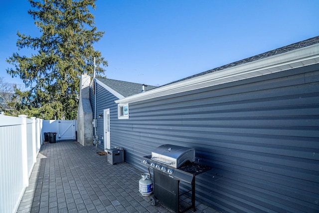 view of patio with a grill, a gate, and fence