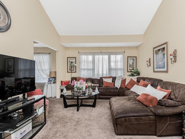 carpeted living area with lofted ceiling