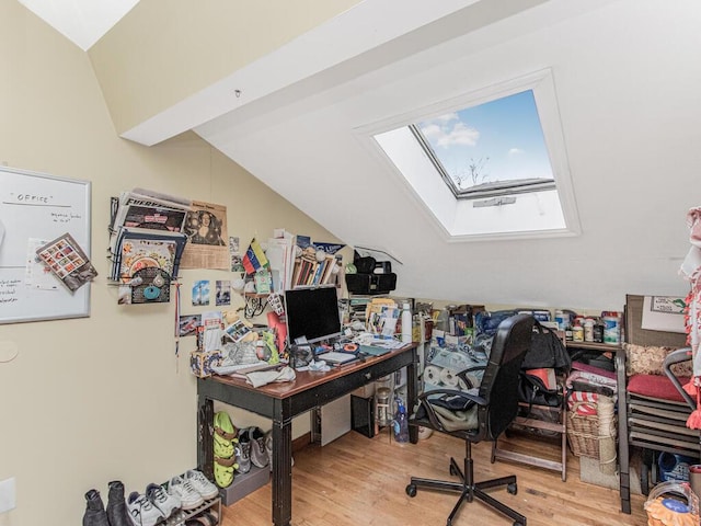 office featuring vaulted ceiling with skylight and wood finished floors