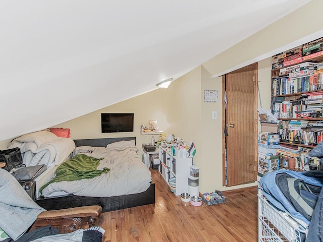 bedroom featuring lofted ceiling and wood finished floors