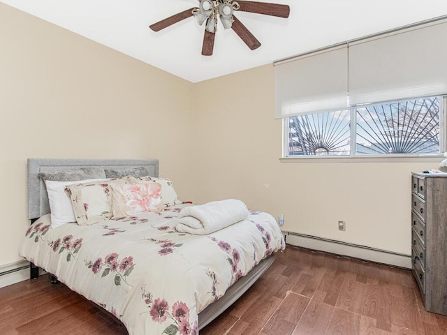 bedroom featuring a baseboard heating unit, wood finished floors, and a ceiling fan