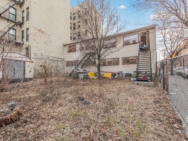 rear view of house with stairway and fence