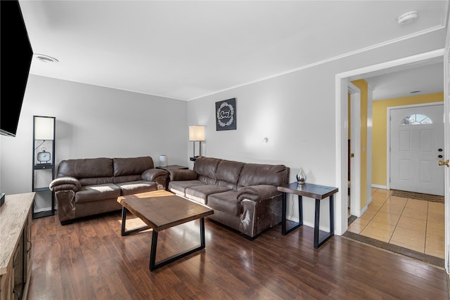 living area featuring baseboards, dark wood finished floors, and crown molding