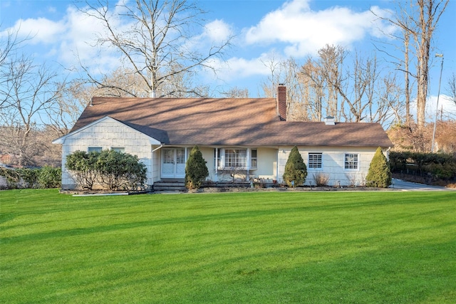 view of front facade featuring entry steps, a chimney, and a front yard