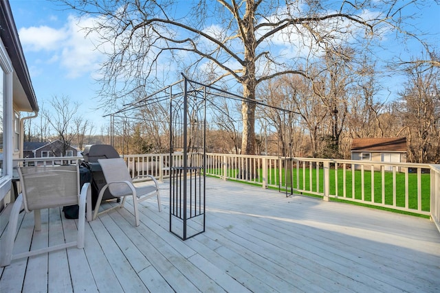 wooden deck with a lawn and an outbuilding