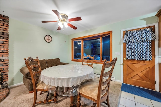 dining room with baseboards, a ceiling fan, light colored carpet, baseboard heating, and light tile patterned flooring