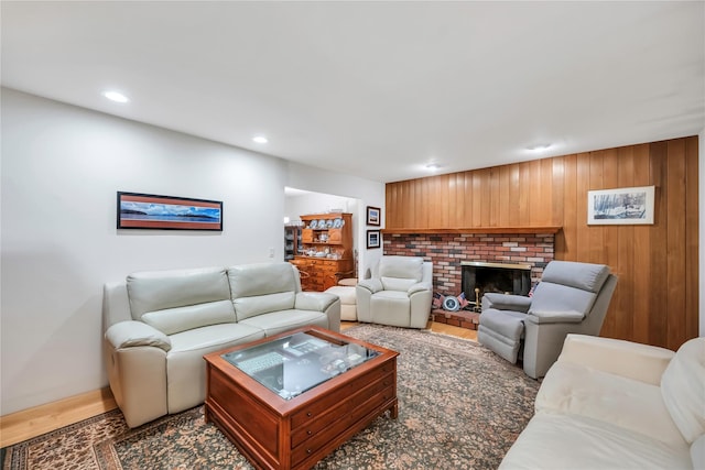 living area featuring wooden walls, a fireplace, wood finished floors, and recessed lighting