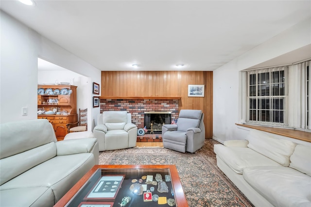 living area featuring light wood-style flooring, a fireplace, and wooden walls