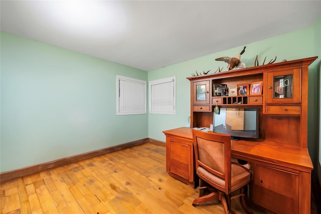 office area with light wood-style flooring and baseboards