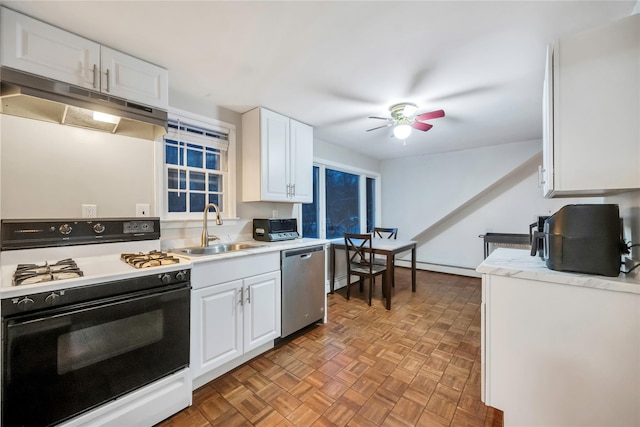 kitchen with white cabinets, a sink, gas range, and under cabinet range hood