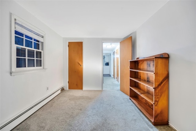 unfurnished room featuring light colored carpet and baseboard heating