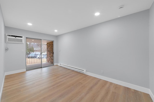 empty room with light wood-style floors, an AC wall unit, baseboards, and baseboard heating