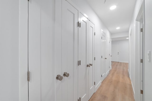 hall with baseboards, light wood-style flooring, and recessed lighting