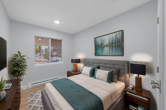 bedroom with a baseboard heating unit, recessed lighting, wood finished floors, and baseboards