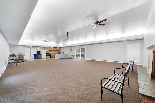 unfurnished room featuring ceiling fan, carpet floors, baseboard heating, and a fireplace