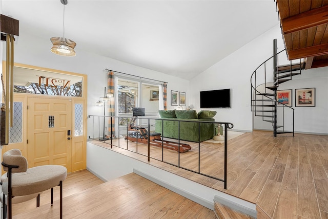 interior space featuring stairway, wood finished floors, and high vaulted ceiling