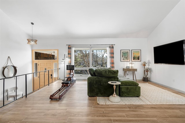 living area with vaulted ceiling and wood finished floors