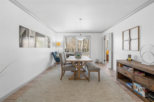 dining room with baseboards, wood finished floors, and ornamental molding